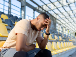 tired young male athlete sits in the stadium on th 2023 03 03 23 42 58 utc