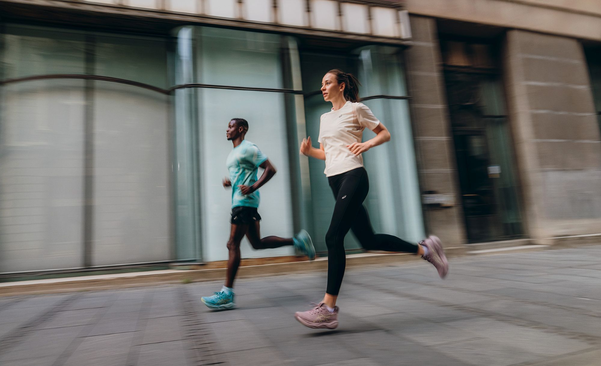 Biegacz i biegaczka w butach ASICS GEL-NIMBUS 29 podczas biegu w mieście